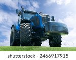 Modern blue agricultural tractor on a background of blue sky.