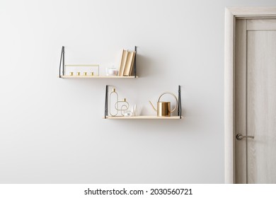 Modern Book Shelves With Decor Hanging On Light Wall