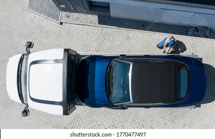 Modern Brand New Convertible Car On Towing Truck Delivered To Client Home. Aerial View. Transportation And Car Sales Theme.