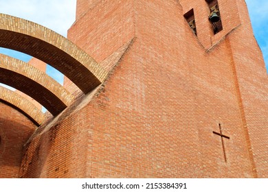 Modern Brick Church With Bell Tower And Bells And Cross On The Facade
