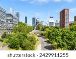 Modern bridge over a street leading to Manchester city centre on a sunny spring day. Modern Skyscrapers are in background.