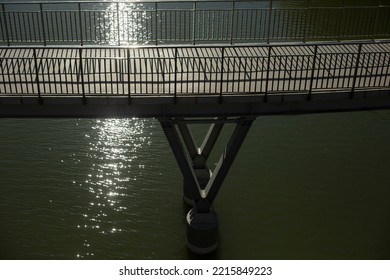 Modern Bridge Over Water. Bridge Supports. Details Of City Park. Railing On Bridge. Water On Sunny Day.