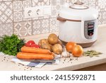 Modern, bright light multi cooker and raw products on table in kitchen. Cooking a healthy, vegetarian dish in a multi cooker, slow cooker.