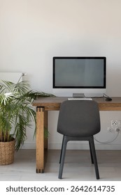 modern bright workplace with desktop computer on wooden table, office workplace with white wall, vertical with copyspace