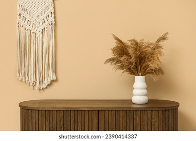 Modern brown chest of drawers and vase with pampas grass near beige wall in room