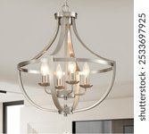 A modern brushed nickel chandelier with five exposed bulbs, hanging in a contemporary living space with neutral tones.