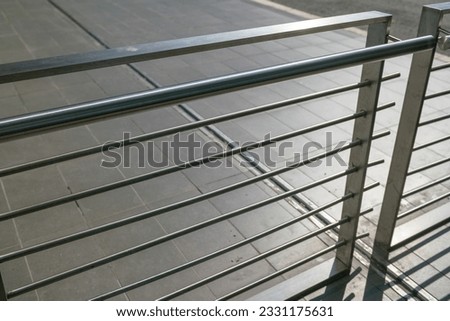 modern building balustrade, detail in polished and satin steel, the parapet protects from falling. Contemporary architecture. handrail geometry.