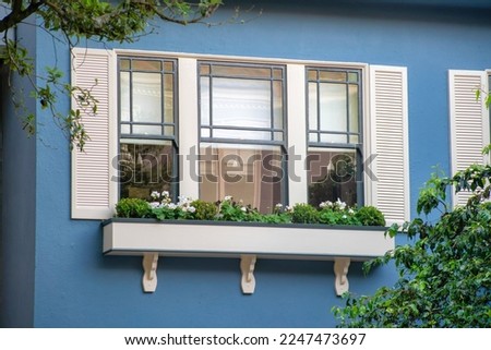Modern building with decorative blue stucco exterior with white shutters and balcony with accent paint on house or home. In the historic districts of downtown san francisco california in the streets.