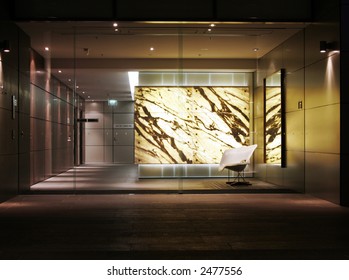 Modern Building Entrance With Glass Doors And Lobby At Night