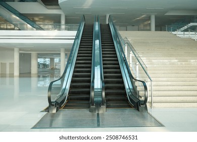 A modern building with an escalator next to a stairway. The building has multiple floors with spacious and airy areas. - Powered by Shutterstock