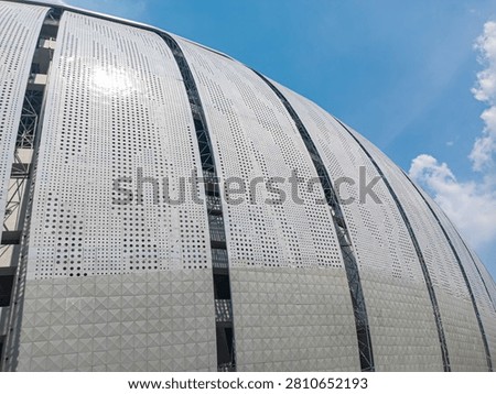 A modern building facade featuring geometric, perforated aluminum panels.
This structure features a curved design and precise perforation patterns for aesthetic appeal.