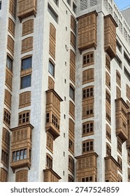 Modern building facade featuring rows of traditional wooden mashrabiya shutter windows