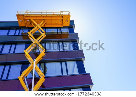 modern building facade repair using a high scissor lift with a platform