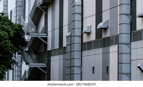 Modern Building Facade with Zigzag Fire Escape Stairs and Ventilation Ducts