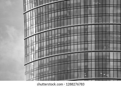 Modern building with reflected sky and cloud in glass window. Black and white.