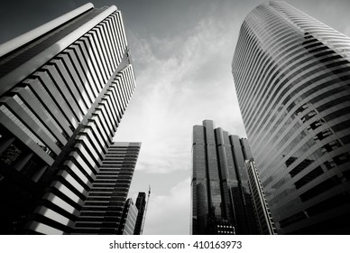 Modern Building With Sun Flare At Bangkok City, Thailand. Bottom View Of Modern Business Skyscrapers. Concepts Of Banking, Financial, Economics, Future. Monochrome Black And White Color.