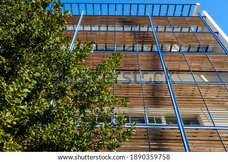 Modern building with wooden boards on the facade to protect from the sun and be of sustainable construction.