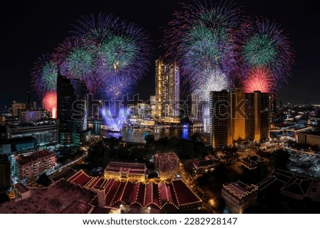 Modern buildings in the city with water reflection, firework, light show at night time.