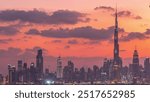 Modern buildings panorama in luxury downtown aerial timelapse of the city after sunset. From day to night transition in financial center Dubai, United Arab Emirates