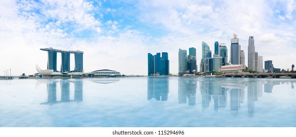 Modern Buildings Of Singapore Skyline Landscape In Business District  With Blue Sky And Reflection In Water Of Marina Bay