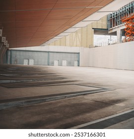 Modern bus stop with, featuring a slanted wooden ceiling, marked parking spaces, and closed metal doors in the background. Clean and spacious urban environment, Santiago de Compostela