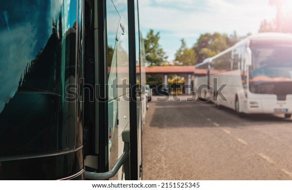 Modern buses for\
transporting people stand at the bus stop. Close-up of an open bus\
door. Light background.