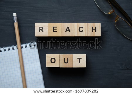 Modern business buzzword - reach out. Top view on wooden table with blocks. Top view. Close up.