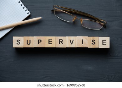 Modern business buzzword - supervise. Top view on wooden table with blocks. Top view. Close up. - Shutterstock ID 1699952968