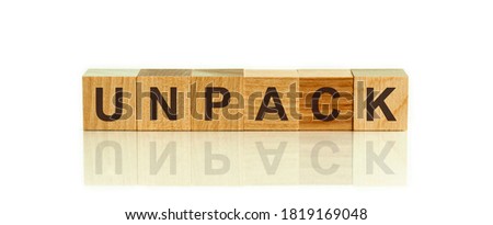 Modern business buzzword - unpack. Word on wooden blocks on a white background. Close up