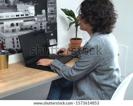 Modern business caucasian woman working on her laptop. She is working from her home, online. Entrepreneur.