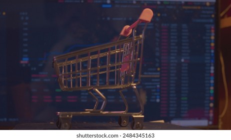 Modern business concept. Stock market. Small shopping cart against the background of a computer monitor with economic indicators. - Powered by Shutterstock