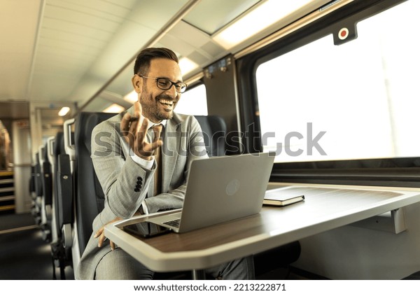 Modern\
business man in the train traveling to work. Man is using laptop,\
mobile phone, and writing down in notebook.\
Business man having a\
video call on laptop during his travel by\
train