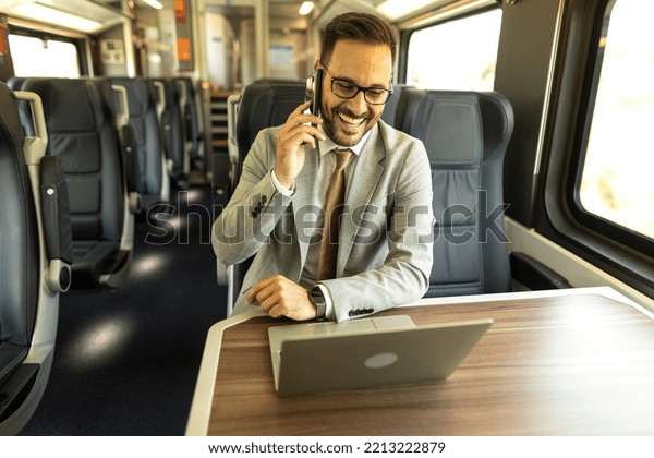 Modern\
business man in the train traveling to work. Man is using laptop,\
mobile phone, and writing down in\
notebook.\
