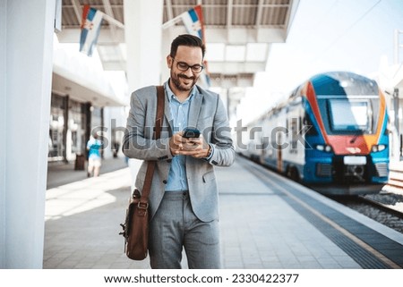 Modern business travel demands modern technology. Confident businessman talking on mobile phone while walking outside the train station with a suitcase. Another success business trip 