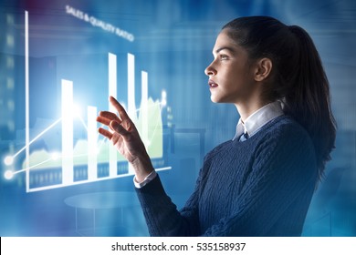 modern business woman using innovative technologies to manage her administrative work, analyzing a digital projected graph