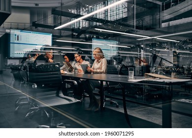 Modern Business. Young Focused Serious Business Women And Men Working In A Conference Room Working On A Project Presentation. Light From A Spacious Office Is Reflected Through The Glass.