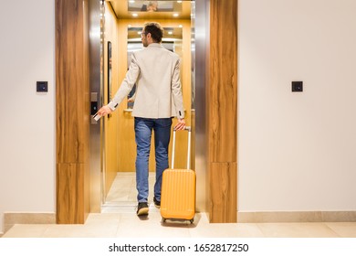 Modern businessman entering the elevator with luggage. Business and travel concept. - Powered by Shutterstock