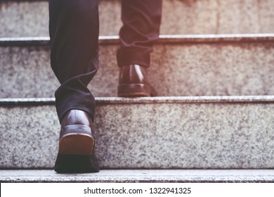 Modern Businessman Working  Close-up Legs Walking Up The Stairs In Modern City. In Rush Hour To Work In Office A Hurry. During The First Morning Of Work. Stairway. Soft Focus.