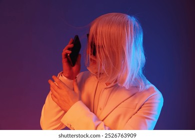 Modern businessperson with long white hair talking on a smartphone, set against a colorful gradient background of blue and purple tones, representing contemporary communication - Powered by Shutterstock