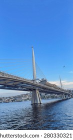 Modern cable stayed bridge spanning across the deep blue water under a clear sky during a bright sunny afternoon day