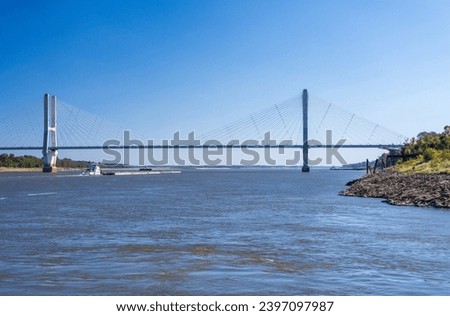 Modern cable-stayed suspension bridge, the Jesse Brent Memorial bridge across the Mississippi river near Greenville with river barge