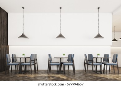 Modern cafe interior with white and wooden walls, a wooden floor, square tables surrounded by gray chairs and many ceiling lamps. 3d rendering