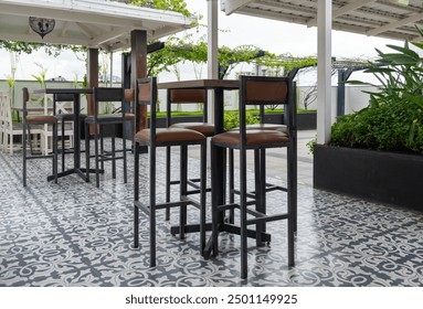 Modern cafe on roof top, black table set for coffee with floral printed tile flooring. empty outdoor table and chair in restaurant. Rooftop restaurant decor. elegant table setting on a hotel rooftop.  - Powered by Shutterstock