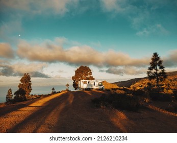 Modern camper van motorhome parked in the nature with sky view. Concept of people and travel vehicle vacation. Adventure vanlife lifestyle and nomadic life. Summer campsite holiday.