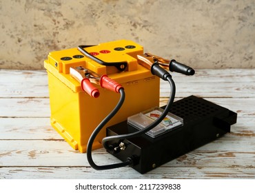 Modern Car Battery And Tester On Table