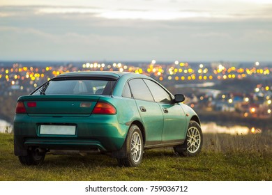 Modern car with blurred bright city lights behind