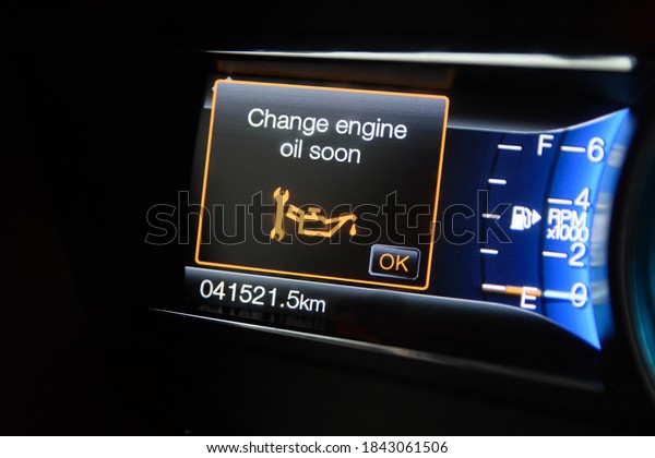 The modern car dashboard computer with color\
infographics warns the driver about changing engine oil soon. Color\
multi-function car display
