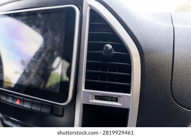 Modern car dashboard featuring touchscreen display, air vent, and control buttons, highlighting automotive technology, driver convenience, and interior design