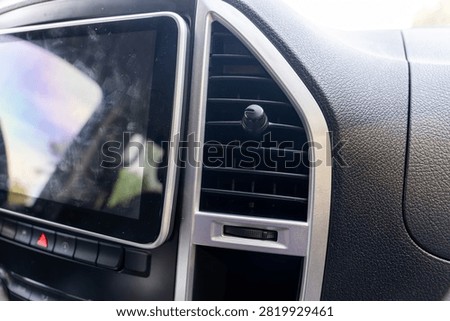 Modern car dashboard featuring touchscreen display, air vent, and control buttons, highlighting automotive technology, driver convenience, and interior design