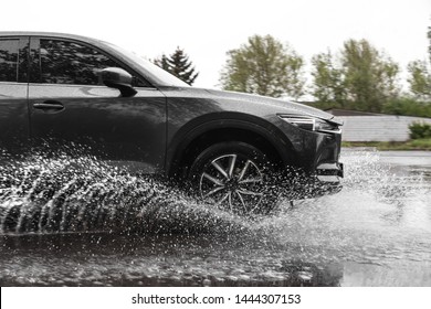 Modern Car Driving Outdoors On Rainy Day